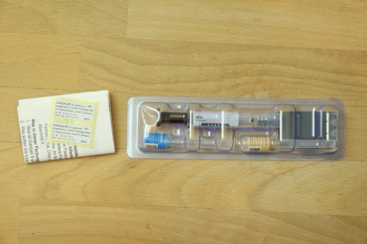 A boxed HPV vaccine (Gardasil 9) with its pre-filled syringe and leaflet, illustrating England's school HPV vaccination programme credited with driving cervical cancer deaths in young women to zero