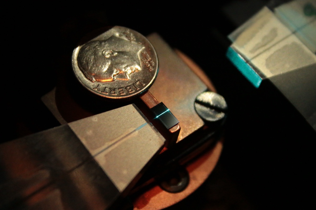 A photonic chip routing a thin line of laser light, illustrating light-based (photonic) computing