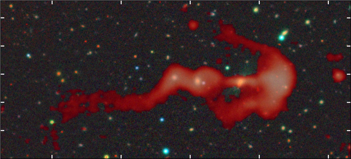 The composite radio-and-optical image of RAD-BAARG, the bow-and-arrow radio galaxy: red LOFAR radio plasma traces a sweeping arc (a bow shock) on one side and a long trailing jet on the other, over a field of background stars and galaxies.